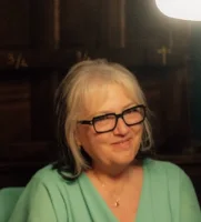 donna con capelli bianchi e occhiali che sorride